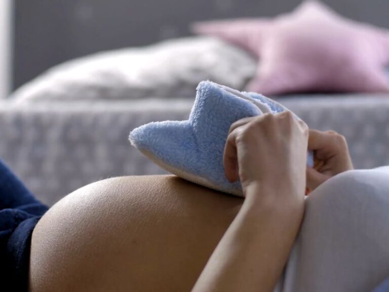 trudna mama drži zimske patofnice na svom stomaku